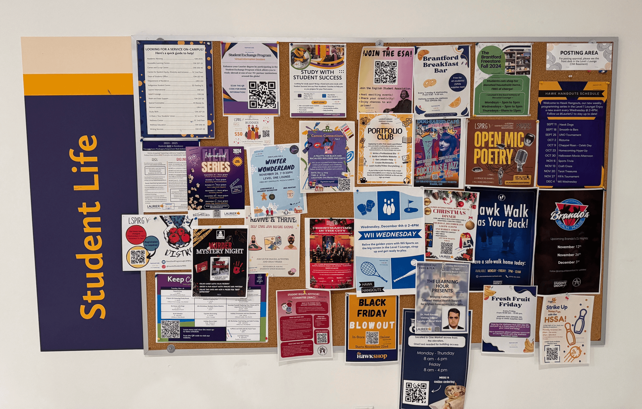 Crowded campus noticeboard covered in student event posters